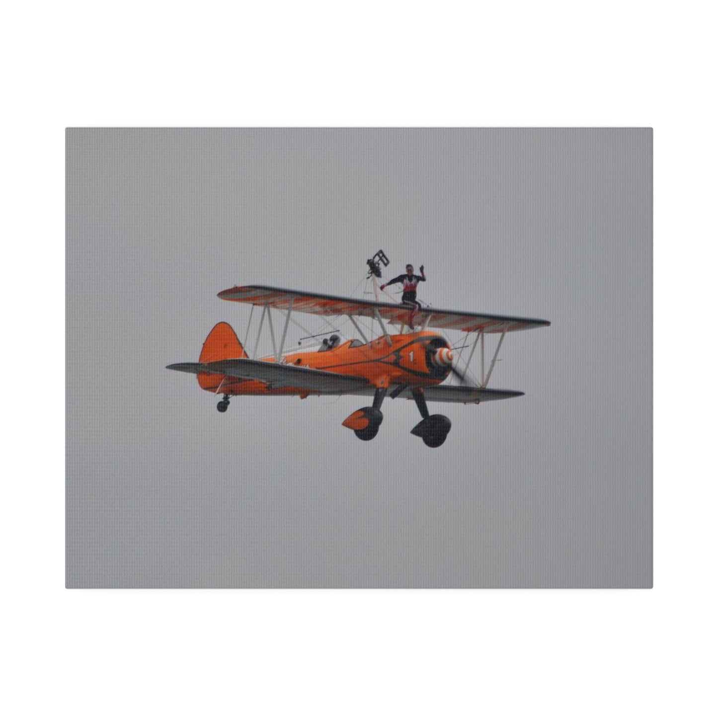 Single Wing Walker Flying From The Left, Front View Much Closer, Person Sitting On The Wing Without The Harness Looking Towards Us, Matte Canvas, Stretched, 0.75" - The Trio Synergize Group