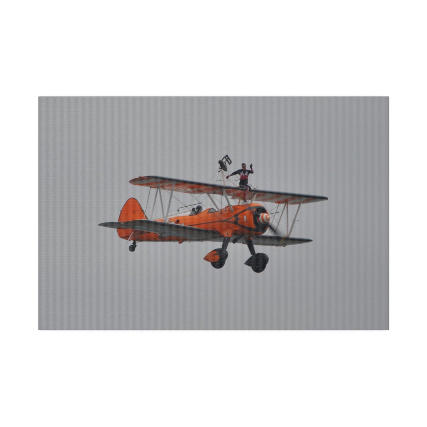 Single Wing Walker Flying From The Left, Front View Much Closer, Person Sitting On The Wing Without The Harness Looking Towards Us, Matte Canvas, Stretched, 0.75" - The Trio Synergize Group