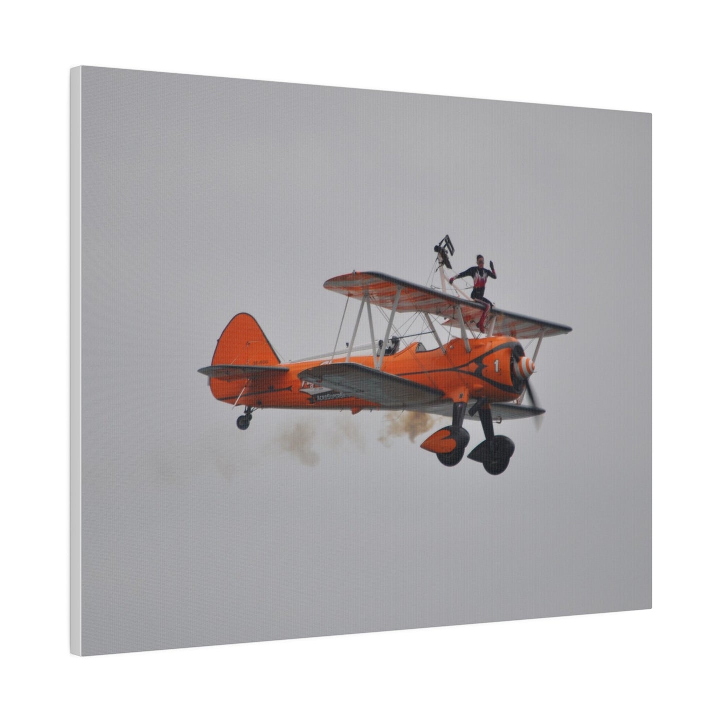 Single Wing Walker Flying From The Left, Front View Much Closer, Person Sitting On The Wing Without The Harness Looking Towards Us With Smoke, Matte Canvas, Stretched, 0.75" - The Trio Synergize Group