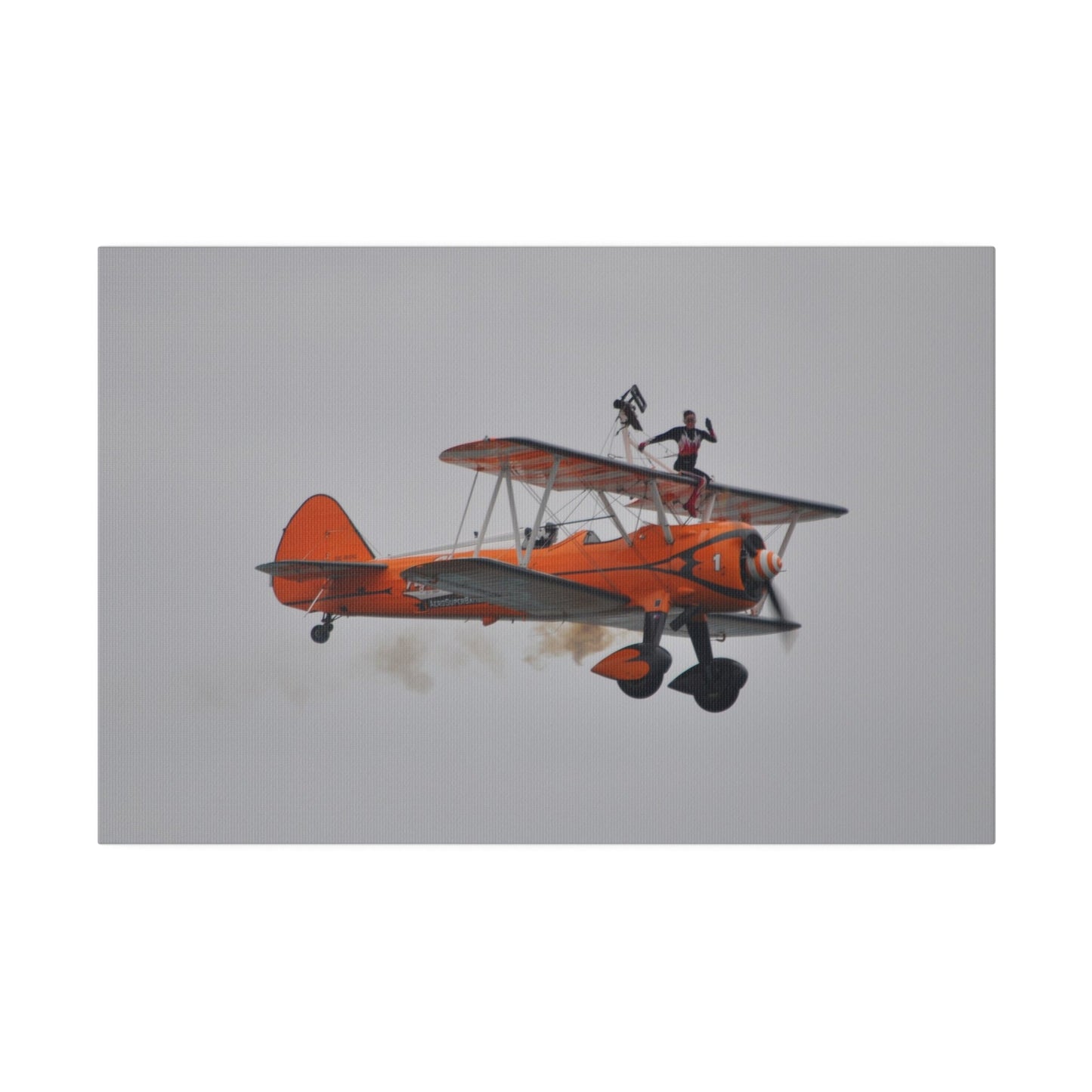 Single Wing Walker Flying From The Left, Front View Much Closer, Person Sitting On The Wing Without The Harness Looking Towards Us With Smoke, Matte Canvas, Stretched, 0.75" - The Trio Synergize Group