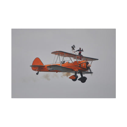 Single Wing Walker Flying From The Left, Front View Much Closer, Person Sitting On The Wing Without The Harness Looking Towards Us With Smoke, Matte Canvas, Stretched, 0.75" - The Trio Synergize Group