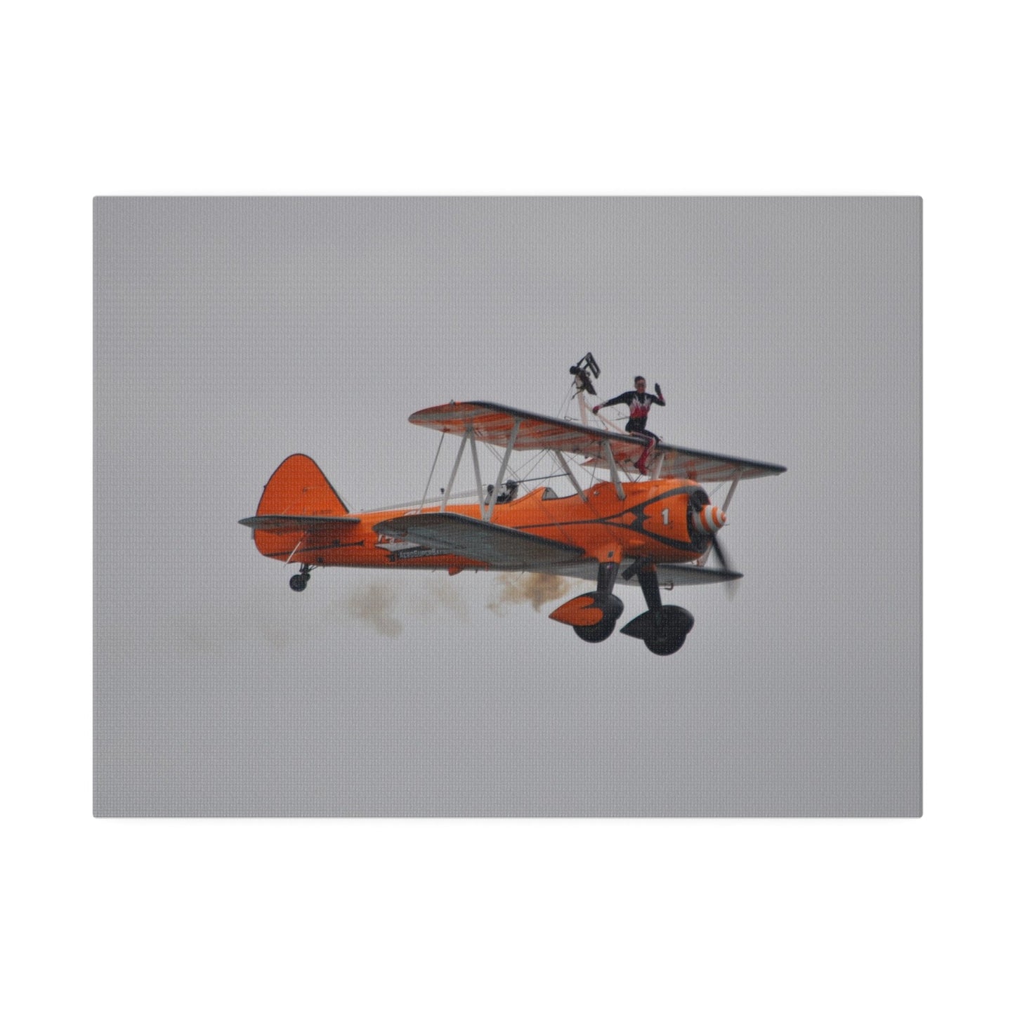 Single Wing Walker Flying From The Left, Front View Much Closer, Person Sitting On The Wing Without The Harness Looking Towards Us With Smoke, Matte Canvas, Stretched, 0.75" - The Trio Synergize Group