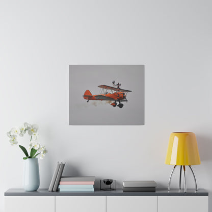 Single Wing Walker Flying From The Left, Front View Much Closer, Person Sitting On The Wing Without The Harness Looking Towards Us With Smoke, Matte Canvas, Stretched, 0.75" - The Trio Synergize Group