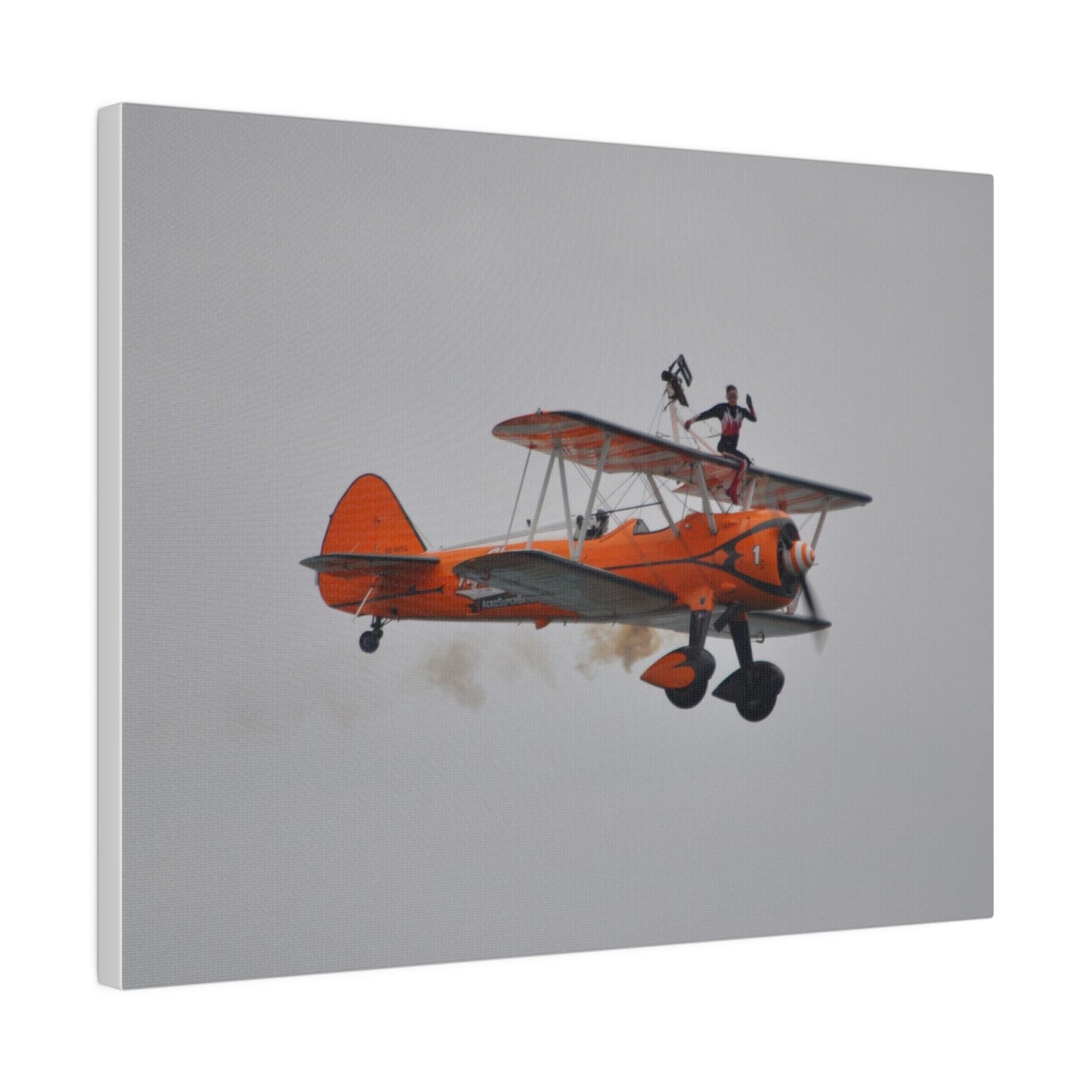 Single Wing Walker Flying From The Left, Front View Much Closer, Person Sitting On The Wing Without The Harness Looking Towards Us With Smoke, Matte Canvas, Stretched, 0.75" - The Trio Synergize Group