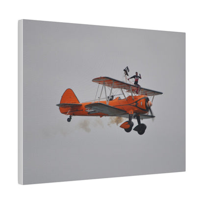 Single Wing Walker Flying From The Left, Front View Much Closer, Person Sitting On The Wing Without The Harness Looking Towards Us With Smoke, Matte Canvas, Stretched, 0.75" - The Trio Synergize Group