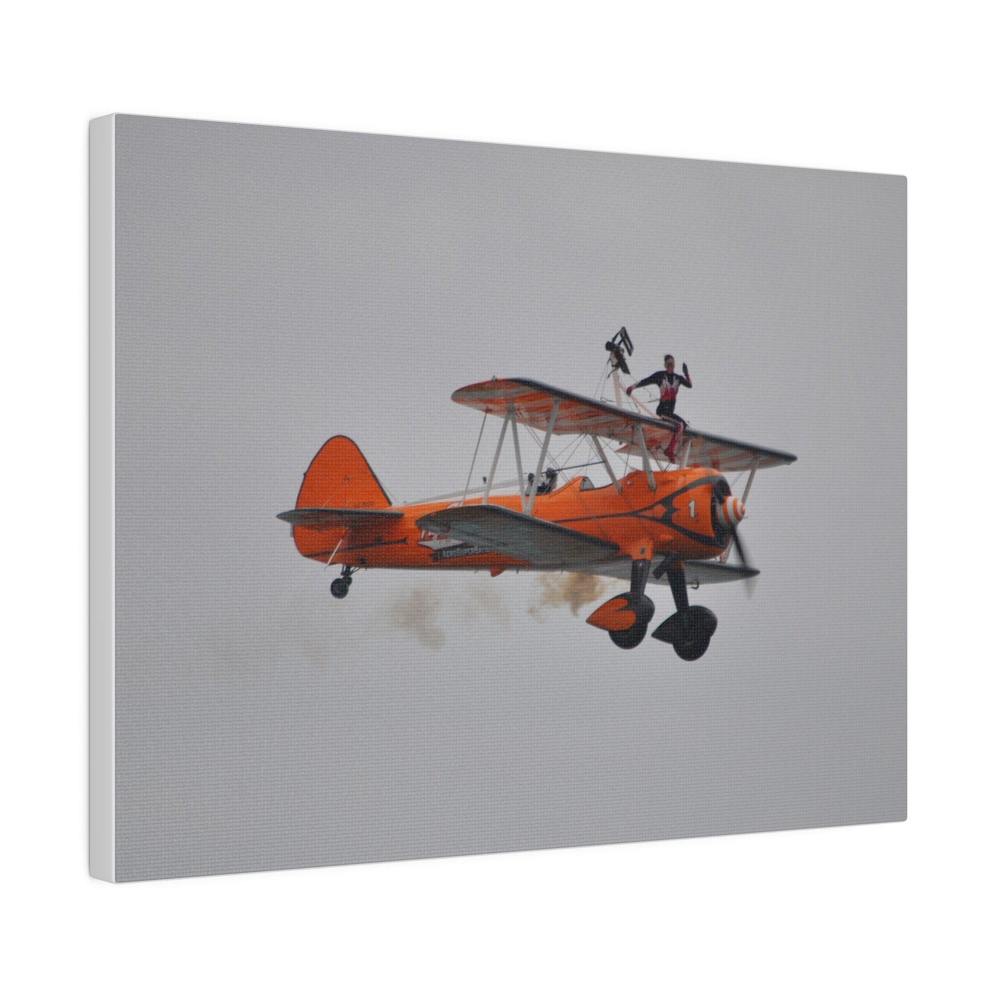 Single Wing Walker Flying From The Left, Front View Much Closer, Person Sitting On The Wing Without The Harness Looking Towards Us With Smoke, Matte Canvas, Stretched, 0.75" - The Trio Synergize Group