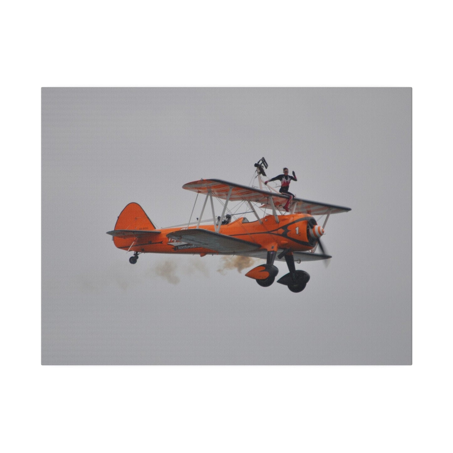 Single Wing Walker Flying From The Left, Front View Much Closer, Person Sitting On The Wing Without The Harness Looking Towards Us With Smoke, Matte Canvas, Stretched, 0.75" - The Trio Synergize Group