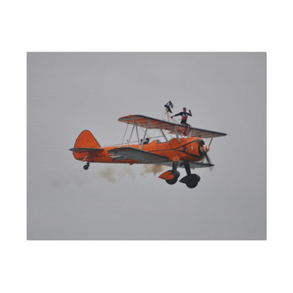 Single Wing Walker Flying From The Left, Front View Much Closer, Person Sitting On The Wing Without The Harness Looking Towards Us With Smoke, Matte Canvas, Stretched, 0.75" - The Trio Synergize Group