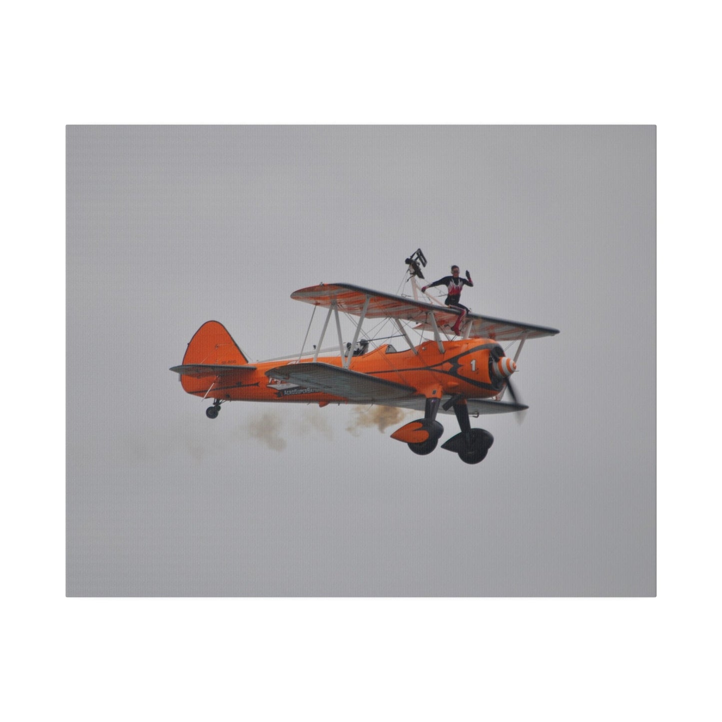 Single Wing Walker Flying From The Left, Front View Much Closer, Person Sitting On The Wing Without The Harness Looking Towards Us With Smoke, Matte Canvas, Stretched, 0.75" - The Trio Synergize Group
